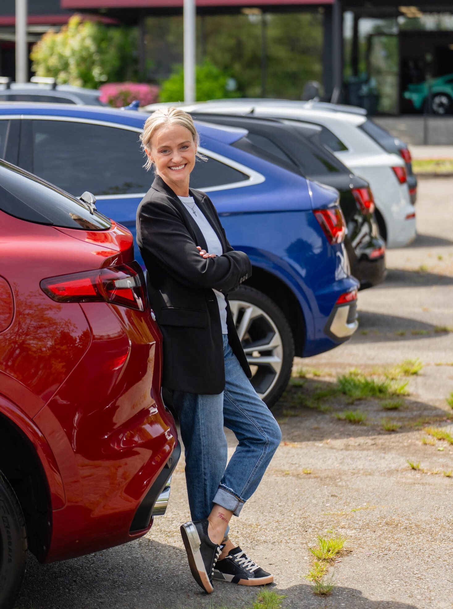 Joli standing beside a car in a lot, ready to help you sell
